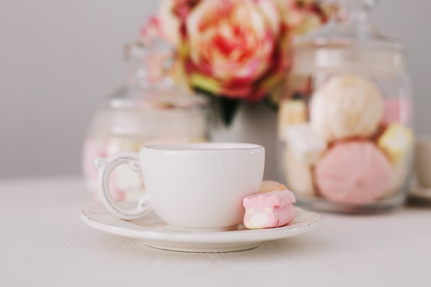 White cup with marshmallows on white background. Romantic breakfast. Concept of holiday, birthday, Easter, 14 February, 8 March. flat lay