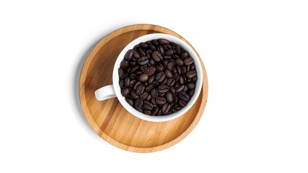 White cup on wooden plate with coffee beans isolated.