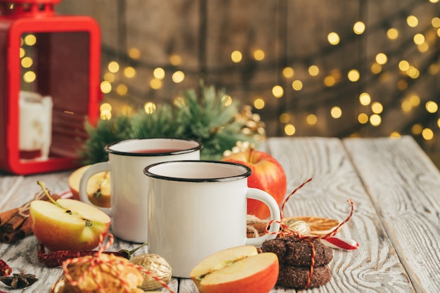 White cups of glint wine on wooden table close up