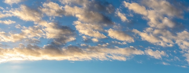 夕陽に照らされた青い空の白い巻き毛の雲