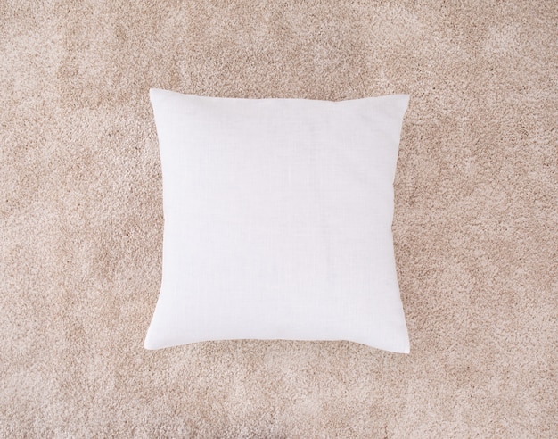 Photo white cushion on the brown mat. one pillow with burlap case.