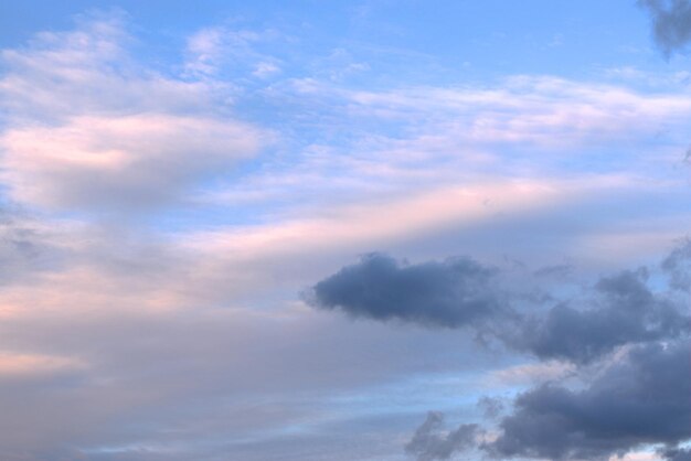 흰색과 검은색 구름이 모니터 배경 배너 화면 보호기의 푸른 하늘을 가로질러 서로를 향해 떠 있습니다.