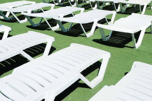 White deck chairs on a green artificial lawn