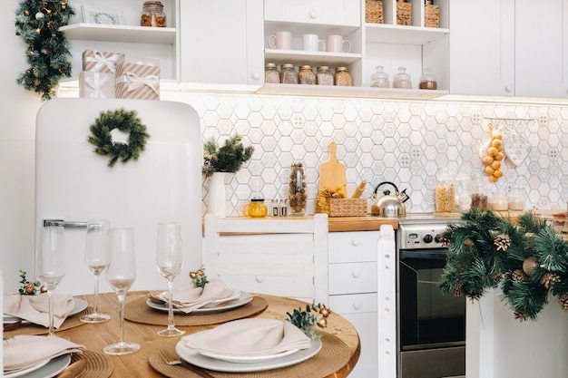 Белая украшенная рождественская кухня с холодильником