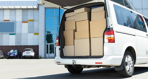 Photo a white delivery service car with boxes inside