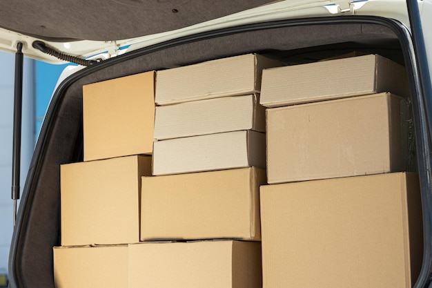 A white delivery service car with boxes inside