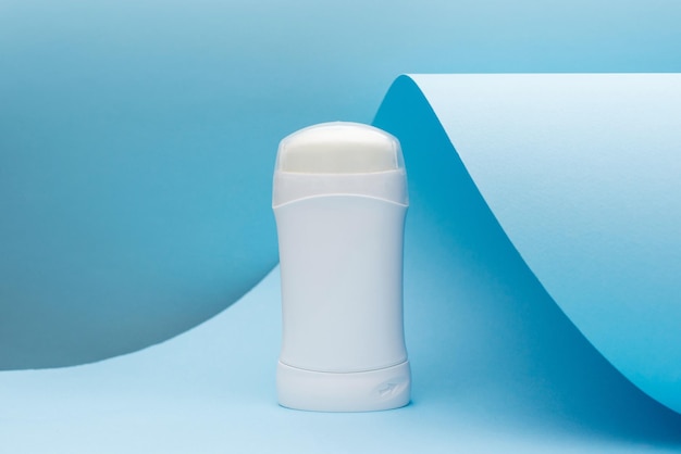 Photo white deodorant or antiperspirant on blue background