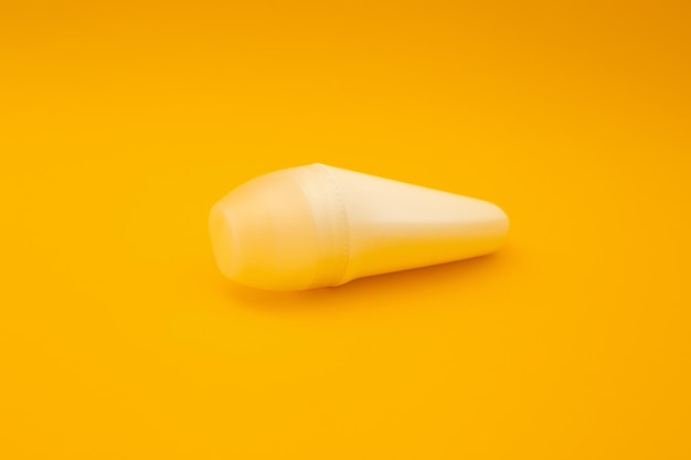 White deodorant on orange background