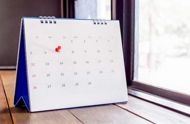 Белый настольный календарь на темном деревянном столе, концепция планирования.