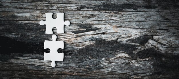 White details of jigsaw puzzle piece on wooden background Concept of working together as a business team The idea of getting involved working for success