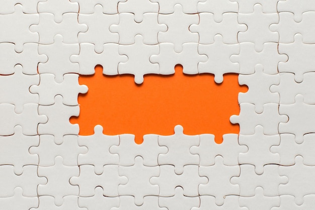 White details of puzzle on orange and place for inscription.
