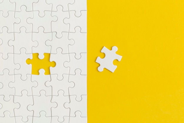 黄色の背景にパズルの白い詳細。ビジネス戦略、チームワーク。