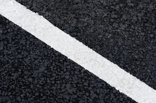 Photo white diagonal marking line on the asphalt road background texture abstract