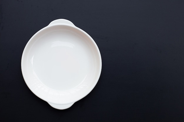 White dish on dark background.