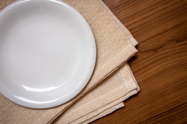 The white dish is placed on a cream tablecloth on the wood table.