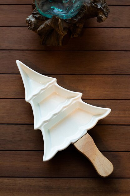 Photo a white dish scrubber sits on a wooden table next to a wooden bowl.