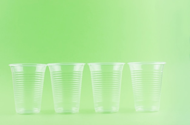사진 밝은 녹색 배경 클로즈업에 흰색 일회용 컵, 접시, 포크, 칼 - 환경 문제 개념, 복사 공간