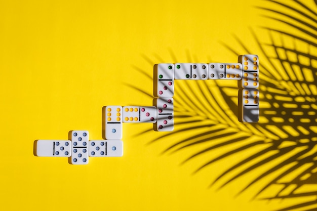 White dominoes with colorful dots on a yellow background board game