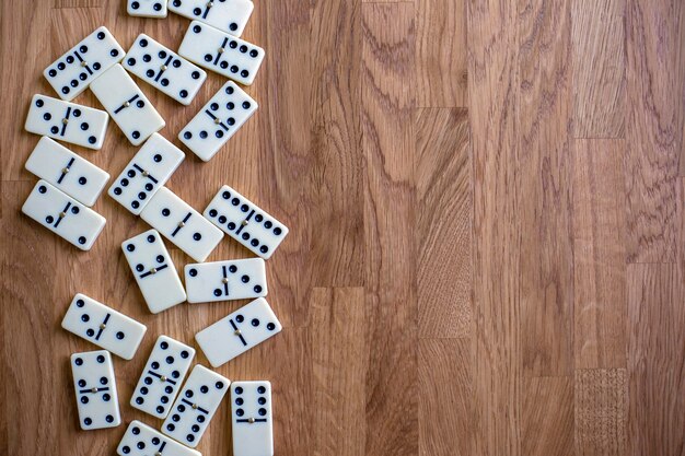 White dominoes on wooden table top view board game place for text