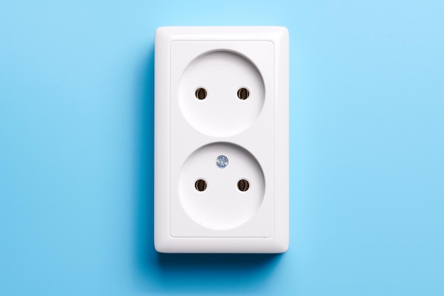 White double socket isolated on blue background Electric lighting concept