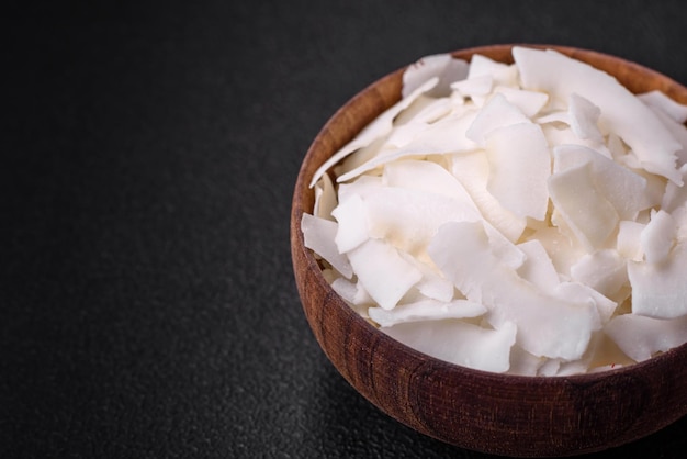 White dry coconut flakes in a wooden bowl prepared for making desserts