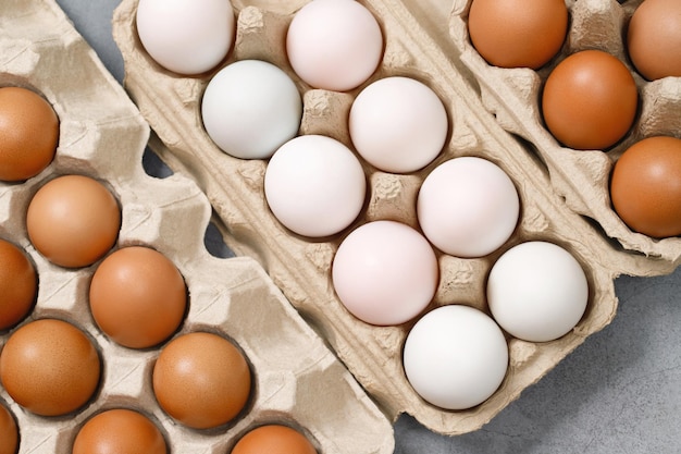 부엌에 있는 식탁에서 요리할 준비가 된 마분지 상자에 있는 흰 오리알과 닭고기 달걀