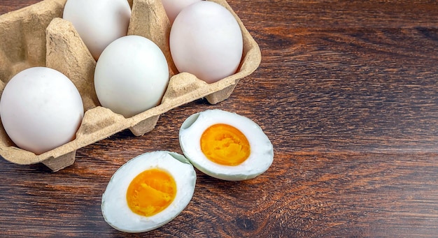 White duck eggs and salted egg food on a wooden table