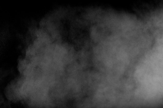 White dust exhale in the air. Motion powder spray burst in dark background.