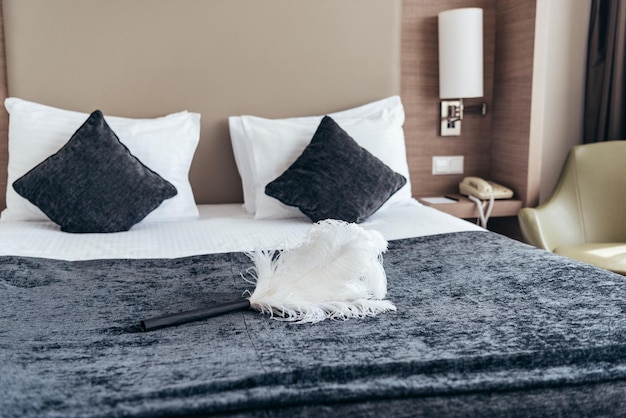 White duster on bed with pillows in hotel room