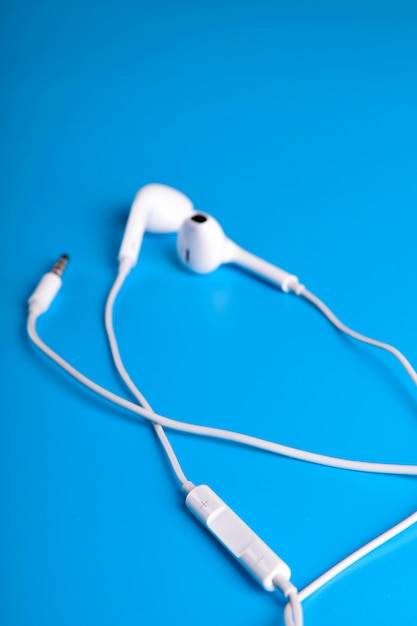 Photo white earphones on blue table