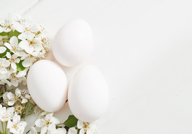 White Easter eggs and spring branch with flowers. Spring easter Flowers Cherry flowering.Spring flowers. Beautiful Orchard.Springtime