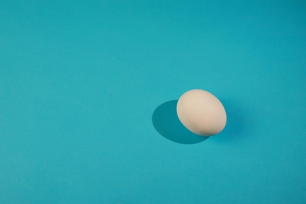 White egg on the blue background in center