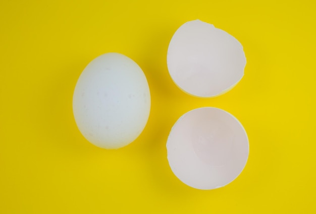 White egg and eggshell on the yellow background Copy space Minimalism original and creative photo Beautiful wallpaper Easter holidays