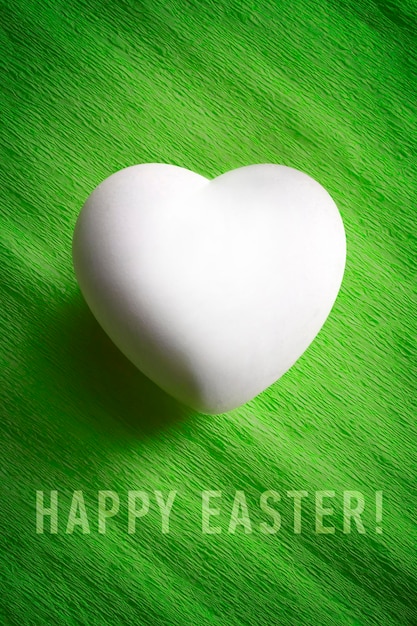 White egg in a heart shape with the words Happy Easter