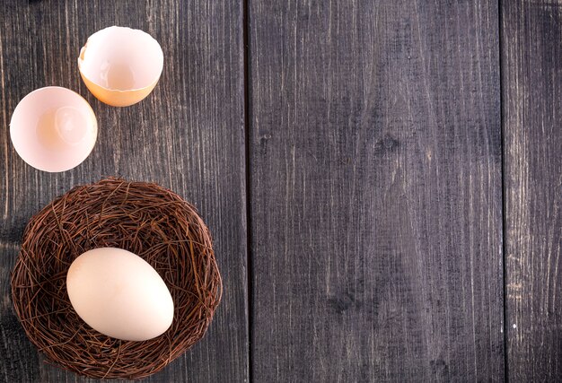 The white egg on the nest on the old wooden background