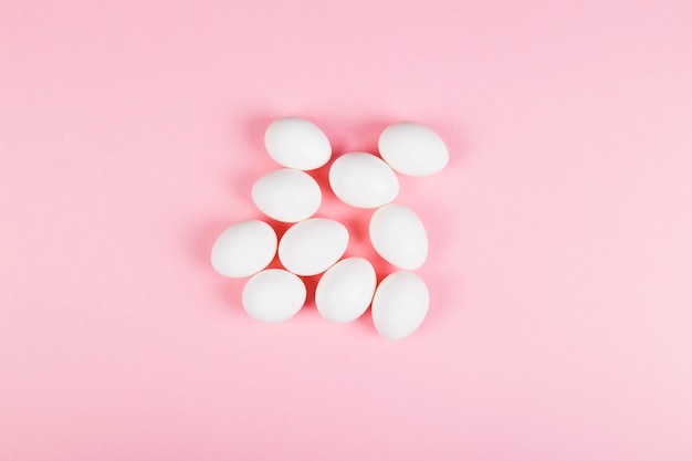 White egg on pink background. Top view