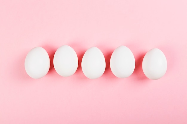 White egg on pink background. Top view