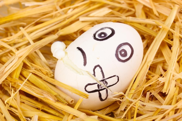 Photo white egg with funny face in straw
