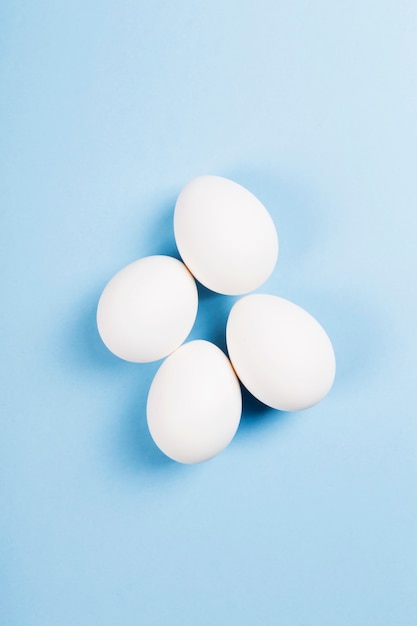 White eggs on blue background. Top view