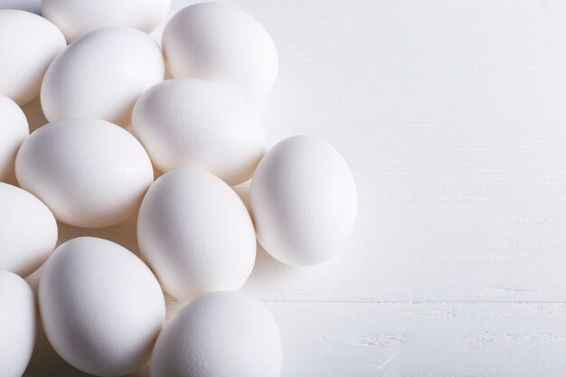 Photo white eggs pattern, on a wooden table.