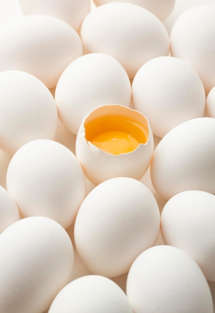 White eggs on a white background one egg is broken unlike the others