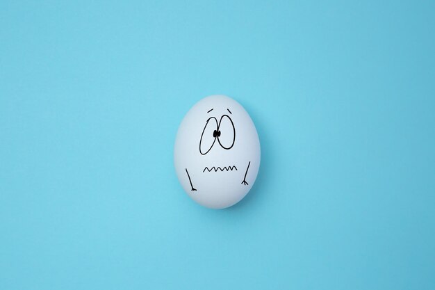 White eggs with a sad face isolated on the background Copy space Emoticons concept Art collage