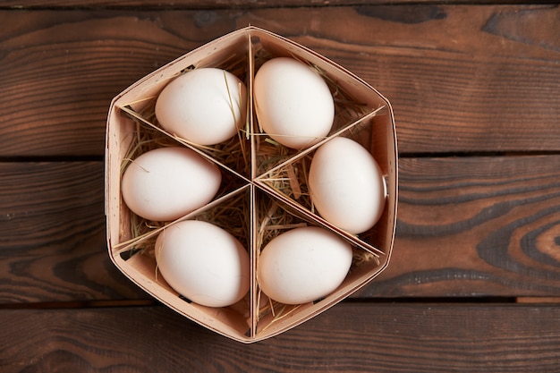 White eggs in wood basket