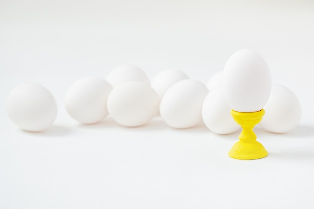 White eggs on wooden coasters forms white background. Getting ready for the Easter holiday.