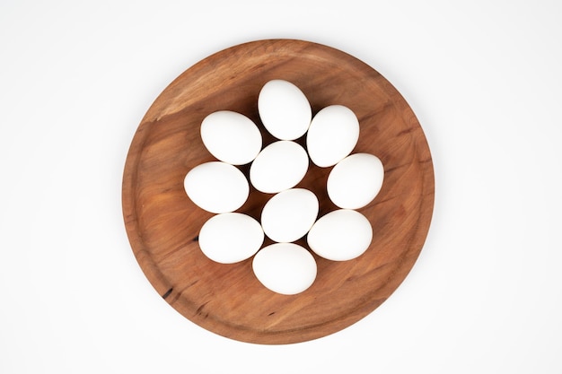 White eggs on a wooden plate on a white background Organic eggs  High quality photo