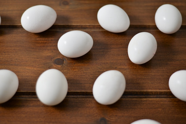 white eggs in wooden plate on wooden background