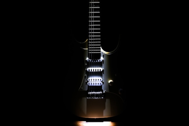Foto chitarra elettrica bianca. manico e tastiera di uno strumento musicale. stile creativo con ombre chiare.
