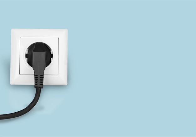壁のコンセントに白い電気プラグ