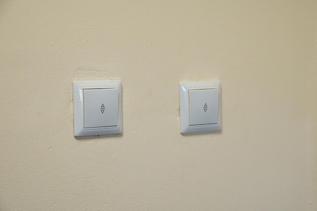 A white electricity switch on the wall in the apartment Energy savings in residential buildings and in production