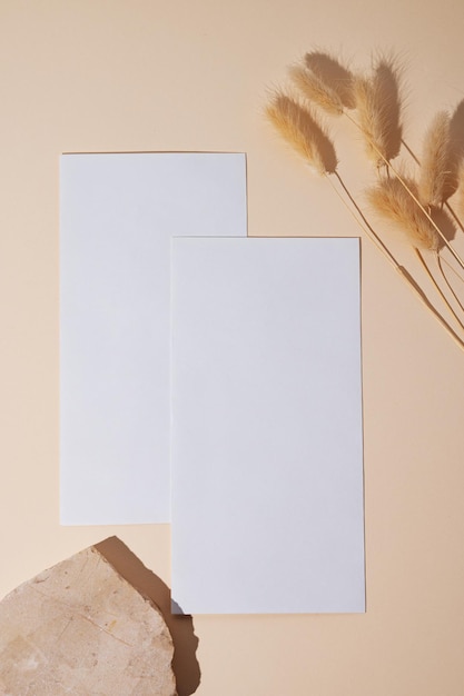 White empty envelope with dried flowers on a beige background with texture stone